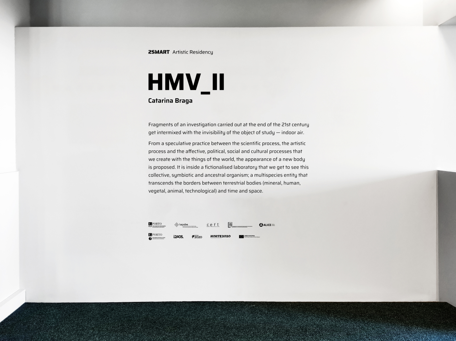 Wall text for the exhibition ‘HMV_III’  by Catarina Braga, describing the project as an investigation into the invisible object of study - indoor air. The text discusses a speculative practice that combines scientific, artistic, and socio-cultural processes to create a new body, a multi-species entity that transcends boundaries.