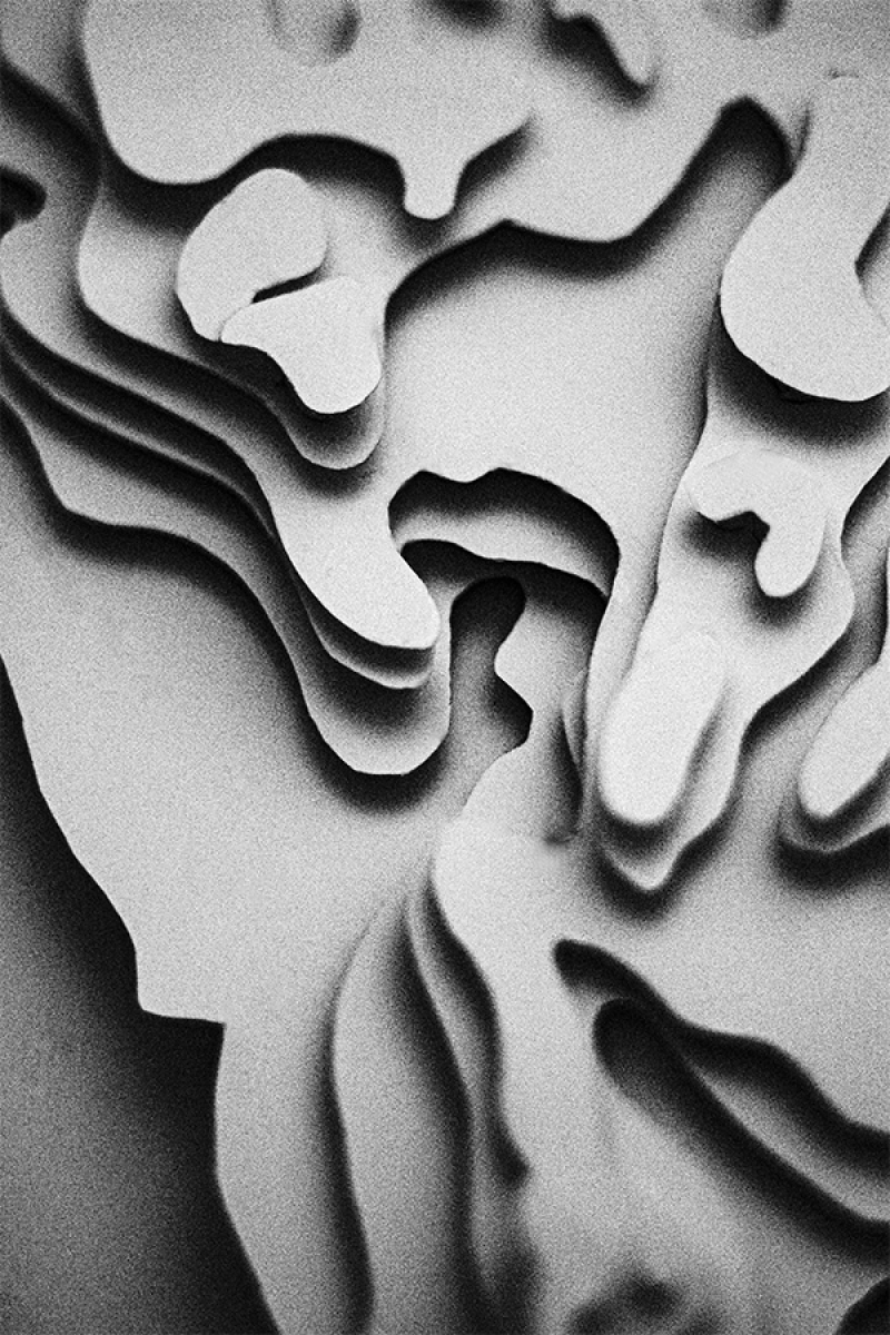 A black and white photo of a 3D paper model of Portugal. The image focuses on a detailed section with layered paper creating a textured representation of the country's varied terrain.