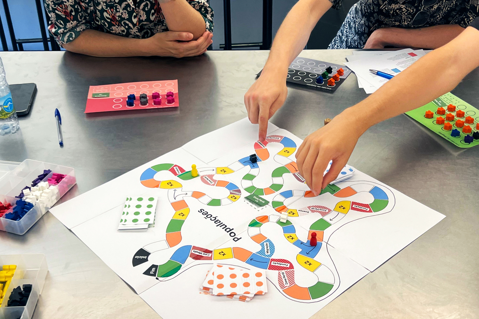 A low-fidelity paper prototype of the Populations board game during a playtest session