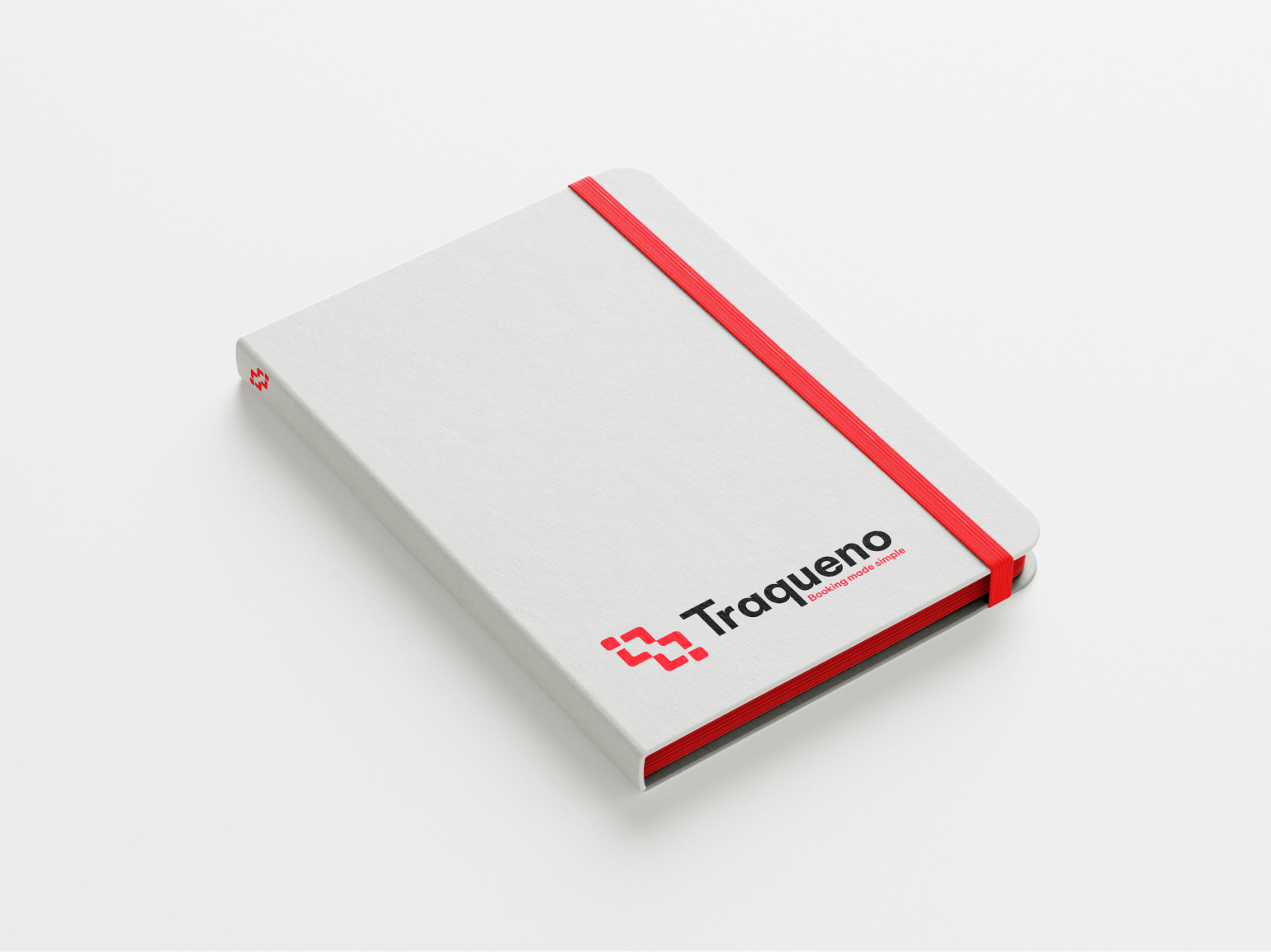 A grey notebook mockup with Traqueno's logotype printed on the cover and a red strap.